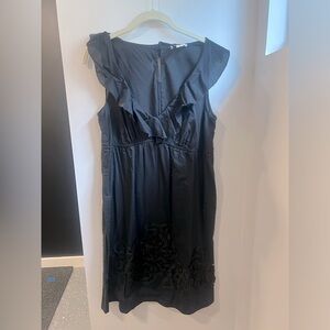 Sleeveless black dress with ruffle detail at neckline